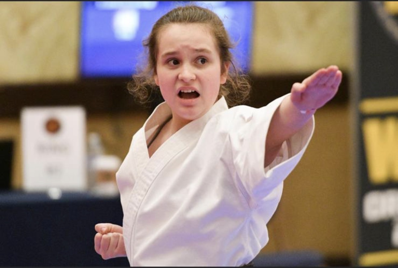 Martial artist demonstrating a karate technique in a white uniform