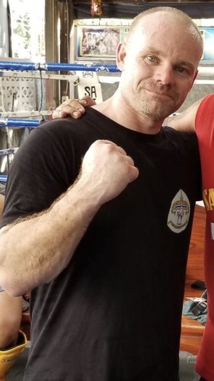 Mike Olson with his fist raised in a boxing gym